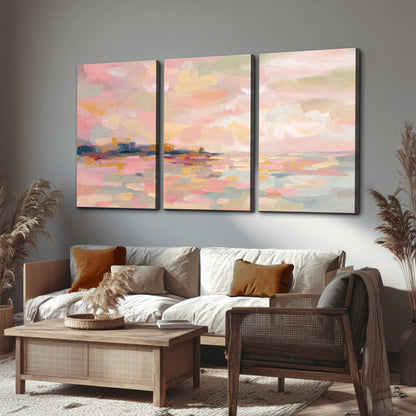 Pink, peach and yellow painted-style sky and water reflections 3 piece canvas wall art displayed in a rustic living room