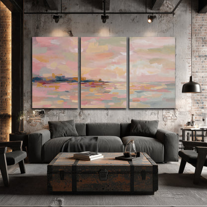 Pink, peach and yellow painted-style sky and water reflections 3 piece canvas wall art displayed in a industrial room