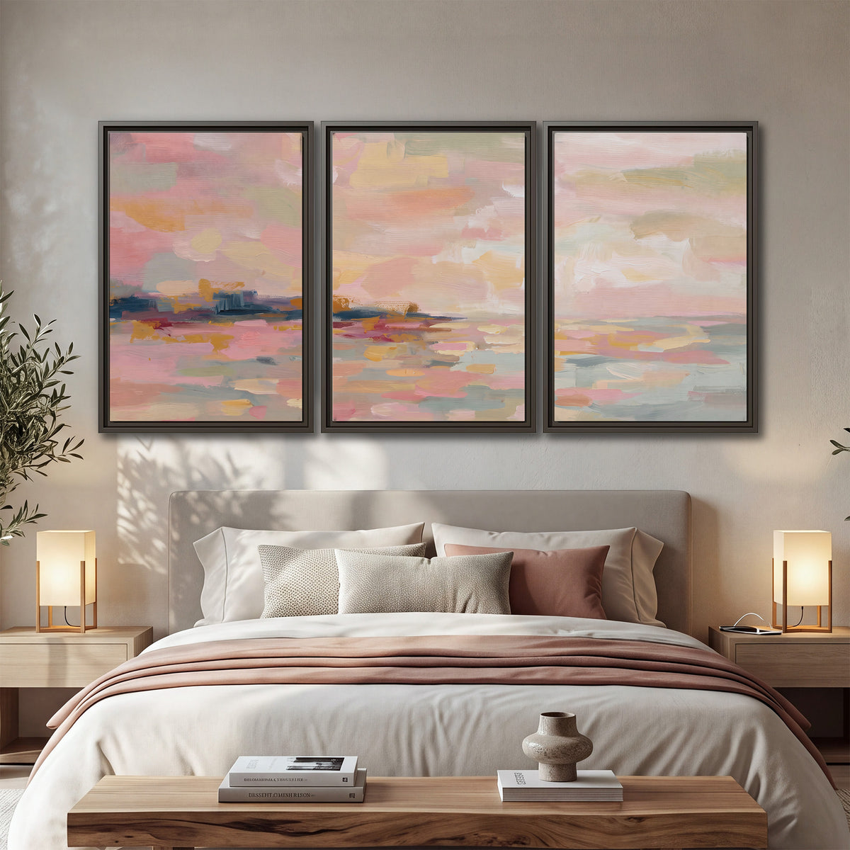 Pink, peach and yellow painted-style sky and water reflections 3 piece framed canvas wall art displayed in a bedroom