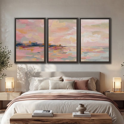 Pink, peach and yellow painted-style sky and water reflections 3 piece framed canvas wall art displayed in a bedroom