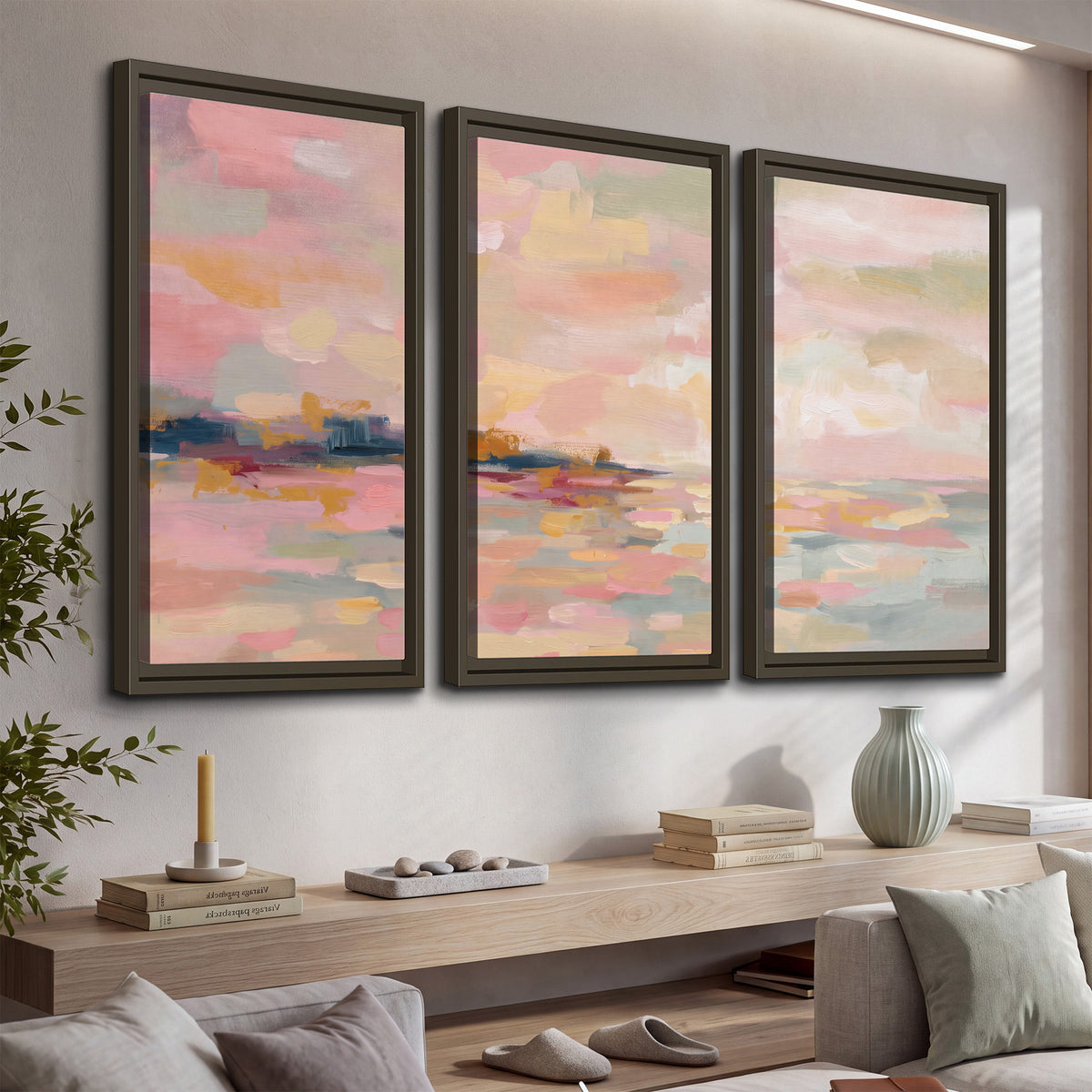 Pink, peach and yellow painted-style sky and water reflections 3 piece framed canvas wall art displayed in a console