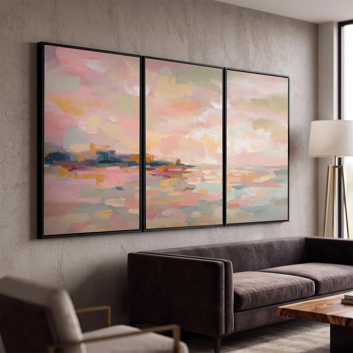 Pink, peach and yellow painted-style sky and water reflections 3 piece framed canvas wall art displayed in a modern living room