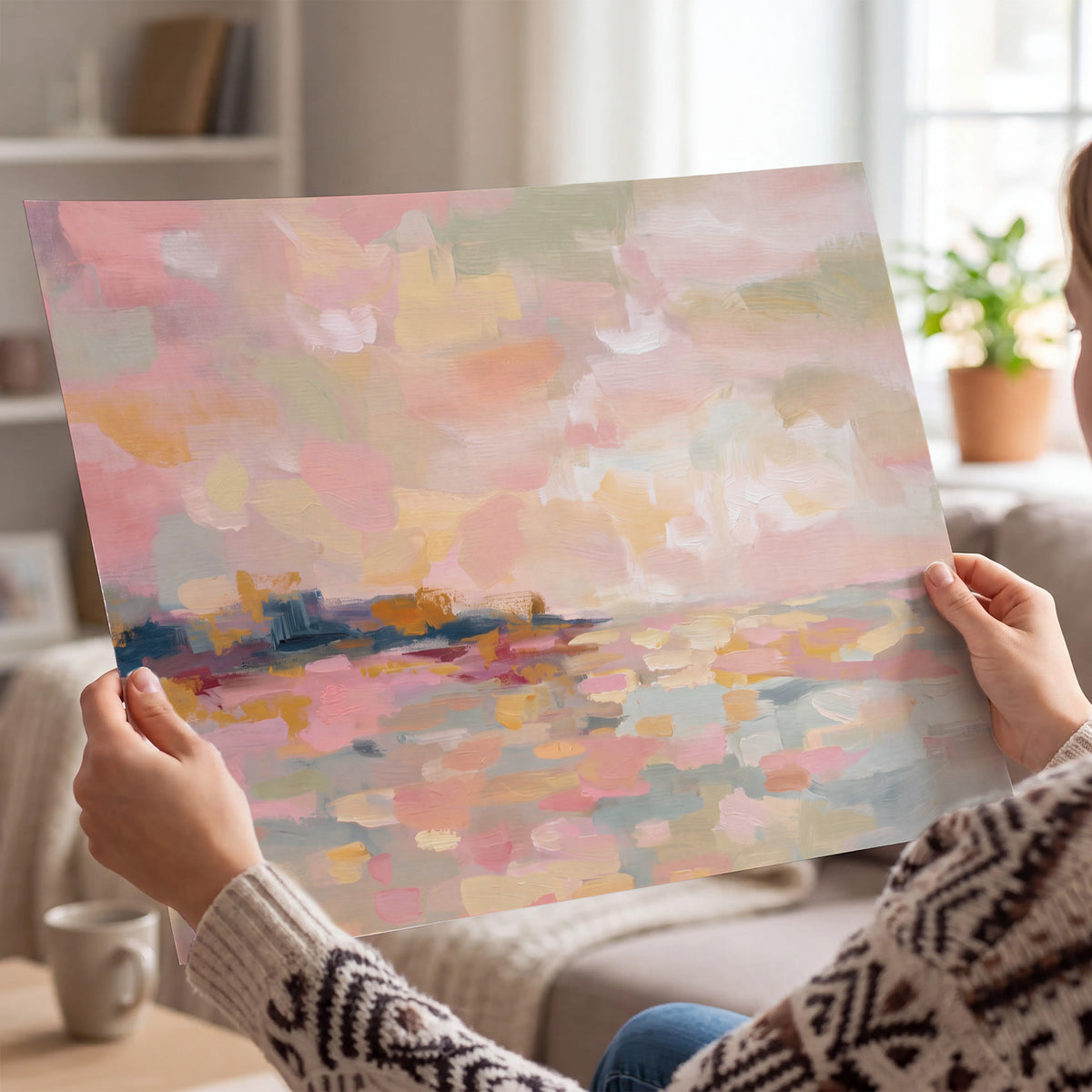 Pink, peach and yellow painted-style sky and water reflections single poster print held in hands