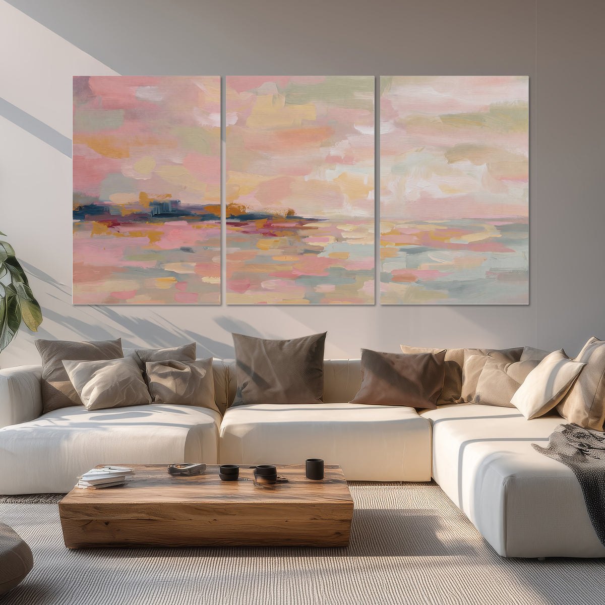Pink, peach and yellow painted-style sky and water reflections set of 3 poster prints displayed in a living room