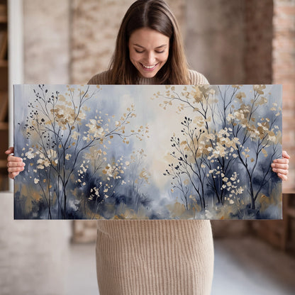 Delicate pale gold-colored branches against a deep blue misty background single canvas wall art held in hands