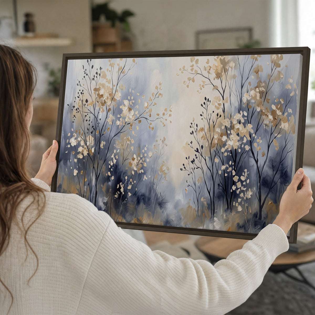 Delicate pale gold-colored branches against a deep blue misty background single framed canvas wall art held in hands