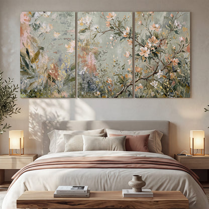 Delicate pink and ivory flowering branches against muted sage green 3 piece canvas wall art displayed in a bedroom