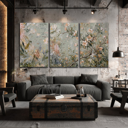 Delicate pink and ivory flowering branches against muted sage green 3 piece canvas wall art displayed in a industrial room