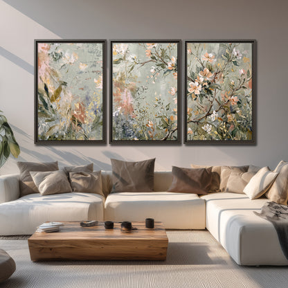 Delicate pink and ivory flowering branches against muted sage green 3 piece framed canvas wall art displayed in a living room