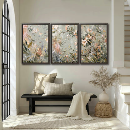 Delicate pink and ivory flowering branches against muted sage green 3 piece framed canvas wall art displayed in a entryway