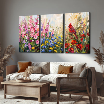 A bright red cardinal among vivid pink, blue and yellow wildflowers 3 piece canvas wall art displayed in a rustic living room