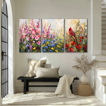 A bright red cardinal among vivid pink, blue and yellow wildflowers 3 piece canvas wall art displayed in a entryway