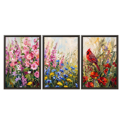 A bright red cardinal among vivid pink, blue and yellow wildflowers 3 piece framed canvas wall art viewed straight on