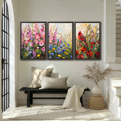 A bright red cardinal among vivid pink, blue and yellow wildflowers 3 piece framed canvas wall art displayed in a entryway
