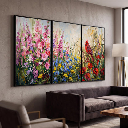A bright red cardinal among vivid pink, blue and yellow wildflowers 3 piece framed canvas wall art displayed in a modern living room