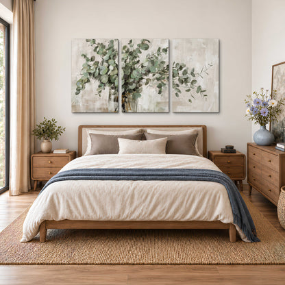 Soft sage eucalyptus leaves and pale stems on a warm cream background 3 piece canvas wall art styled in an interior