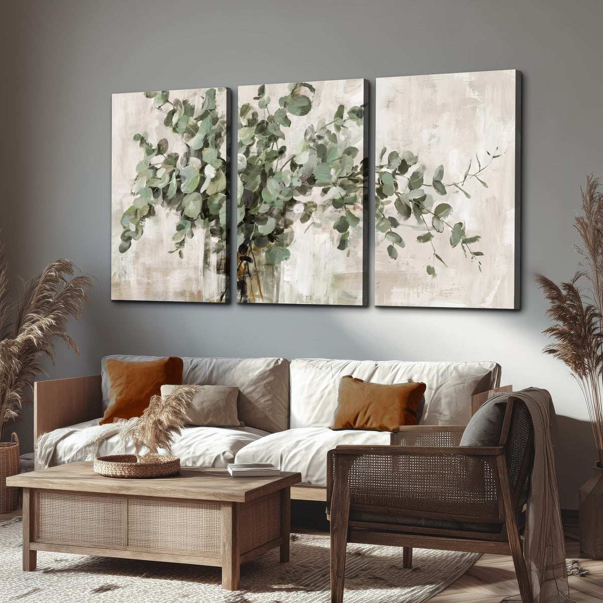 Soft sage eucalyptus leaves and pale stems on a warm cream background 3 piece canvas wall art displayed in a rustic living room