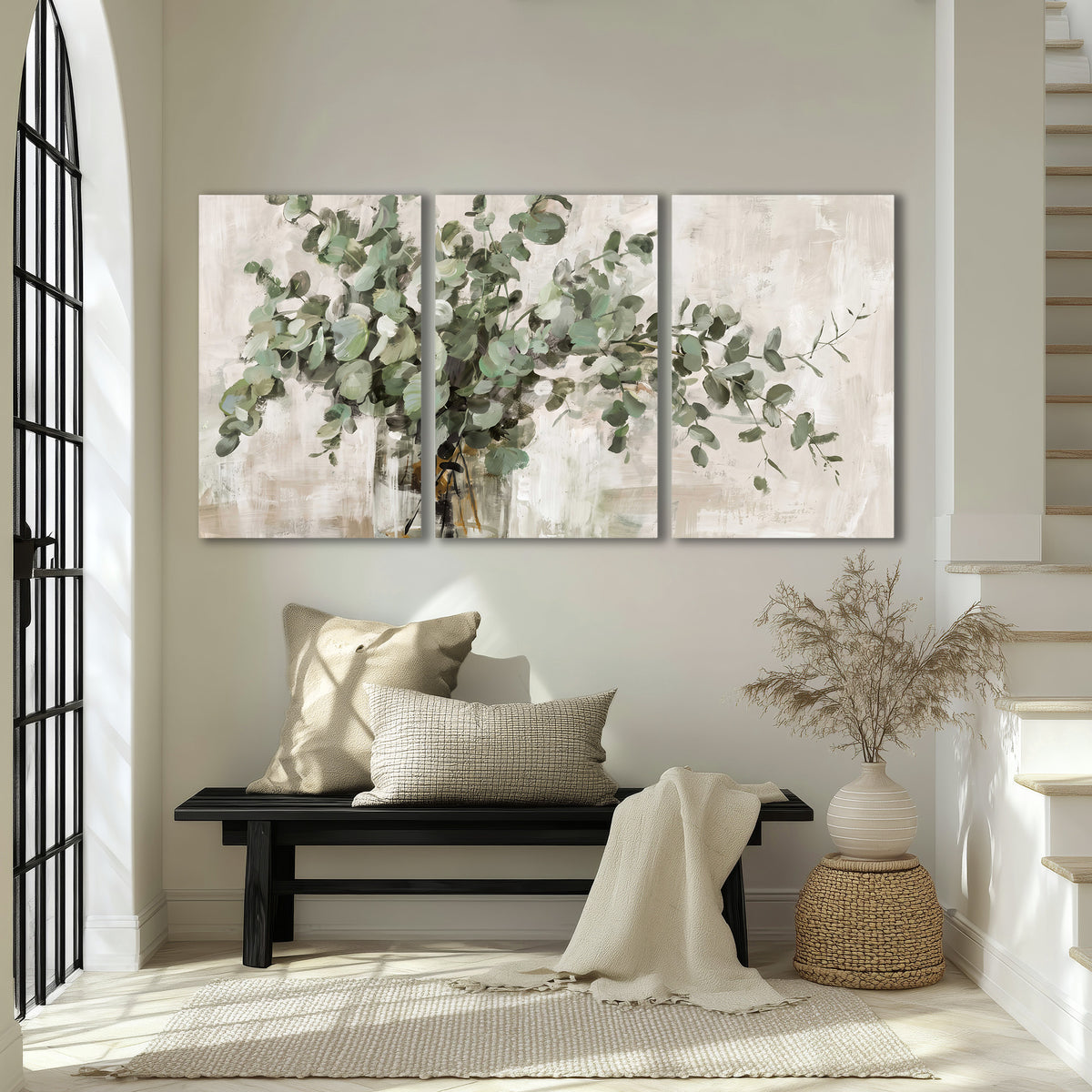 Soft sage eucalyptus leaves and pale stems on a warm cream background 3 piece canvas wall art displayed in a entryway