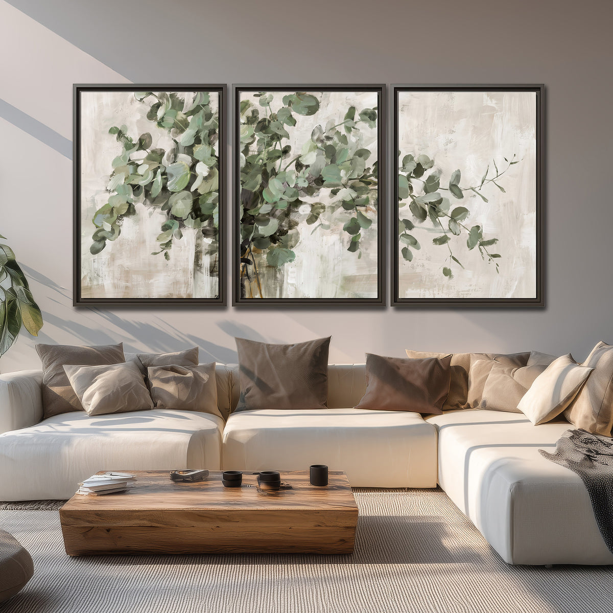 Soft sage eucalyptus leaves and pale stems on a warm cream background 3 piece framed canvas wall art displayed in a living room