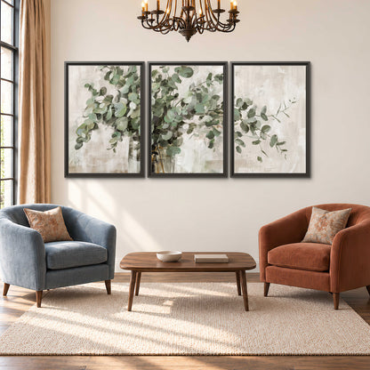 Soft sage eucalyptus leaves and pale stems on a warm cream background 3 piece framed canvas wall art styled in an interior