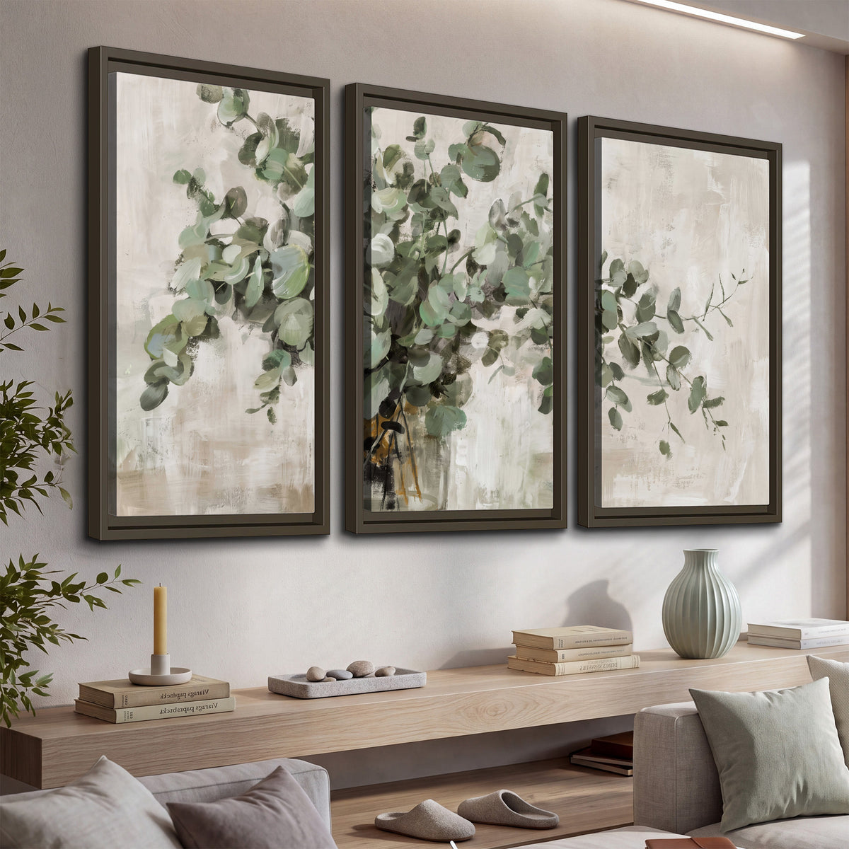 Soft sage eucalyptus leaves and pale stems on a warm cream background 3 piece framed canvas wall art displayed in a console