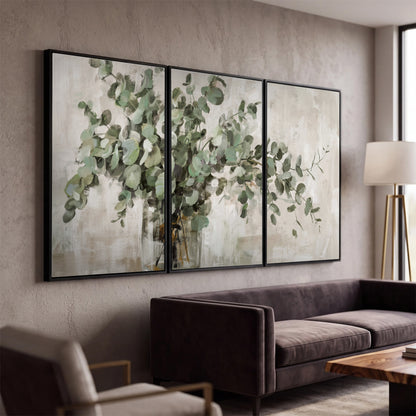 Soft sage eucalyptus leaves and pale stems on a warm cream background 3 piece framed canvas wall art displayed in a modern living room