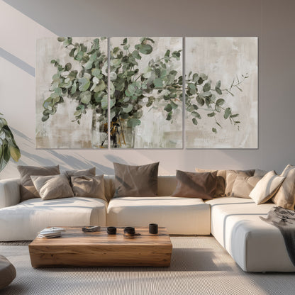 Soft sage eucalyptus leaves and pale stems on a warm cream background set of 3 poster prints displayed in a living room