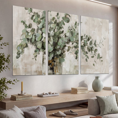 Soft sage eucalyptus leaves and pale stems on a warm cream background set of 3 poster prints displayed in a console