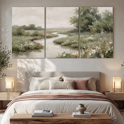 A narrow winding stream through quiet green meadows and trees 3 piece canvas wall art displayed in a bedroom