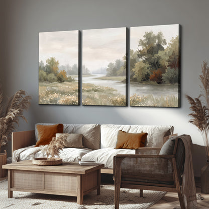 A broad pale river bordered by green trees and small meadow flowers 3 piece canvas wall art displayed in a rustic living room