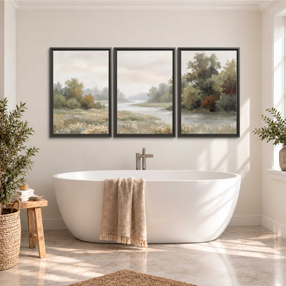 A broad pale river bordered by green trees and small meadow flowers 3 piece framed canvas wall art styled in an interior