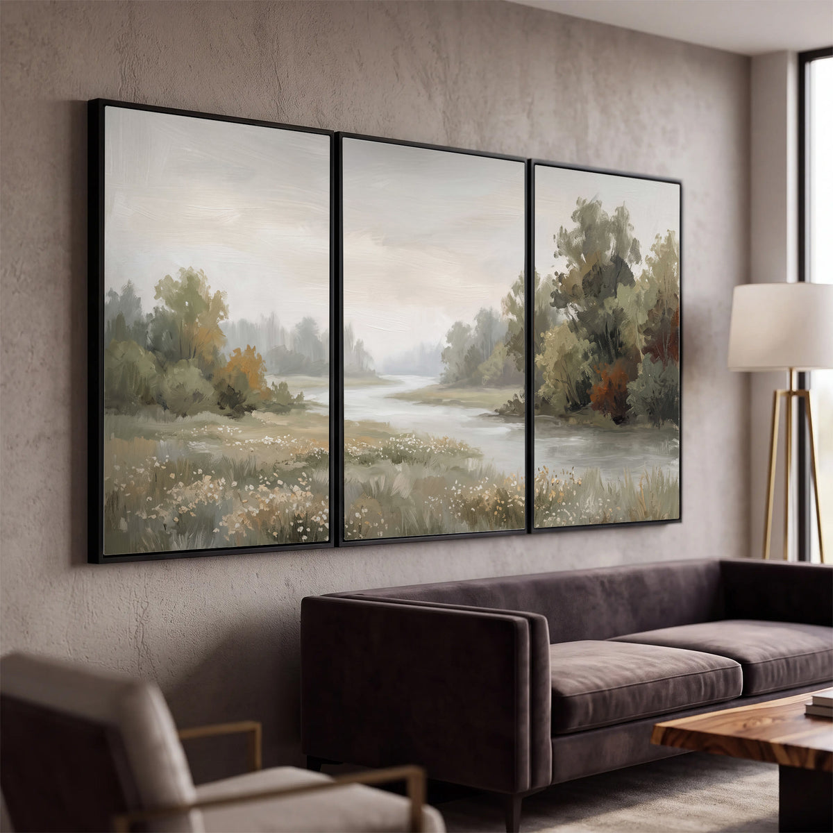 A broad pale river bordered by green trees and small meadow flowers 3 piece framed canvas wall art displayed in a modern living room