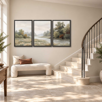 A broad pale river bordered by green trees and small meadow flowers 3 piece framed canvas wall art styled in an interior