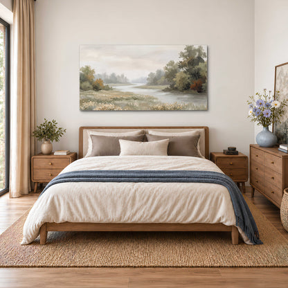 A broad pale river bordered by green trees and small meadow flowers single canvas wall art styled in an interior