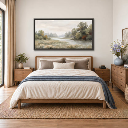 A broad pale river bordered by green trees and small meadow flowers single framed canvas wall art styled in an interior