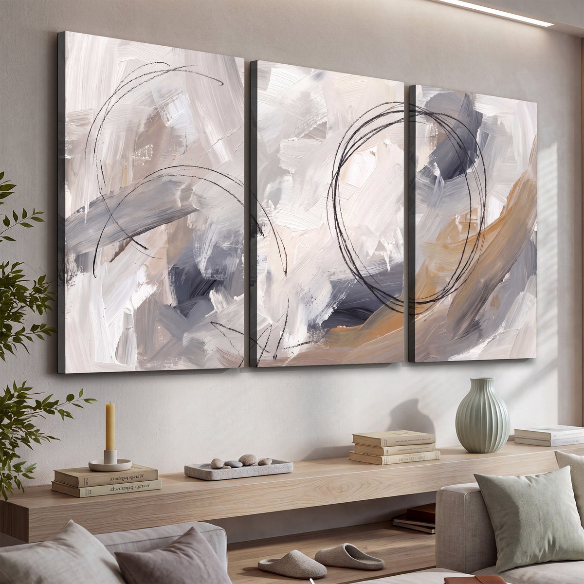Expressive gray and cream abstract forms with fine gold-colored circular lines 3 piece canvas wall art displayed in a console