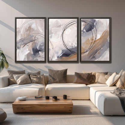 Expressive gray and cream abstract forms with fine gold-colored circular lines 3 piece framed canvas wall art displayed in a living room