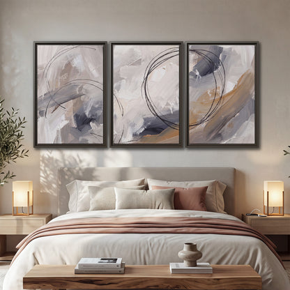 Expressive gray and cream abstract forms with fine gold-colored circular lines 3 piece framed canvas wall art displayed in a bedroom