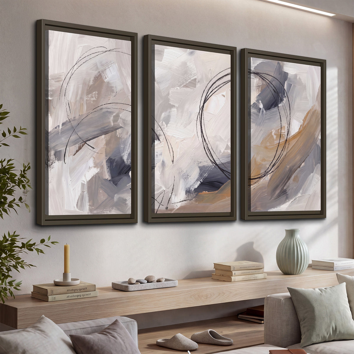 Expressive gray and cream abstract forms with fine gold-colored circular lines 3 piece framed canvas wall art displayed in a console