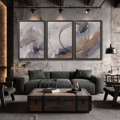 Expressive gray and cream abstract forms with fine gold-colored circular lines 3 piece framed canvas wall art displayed in a industrial room