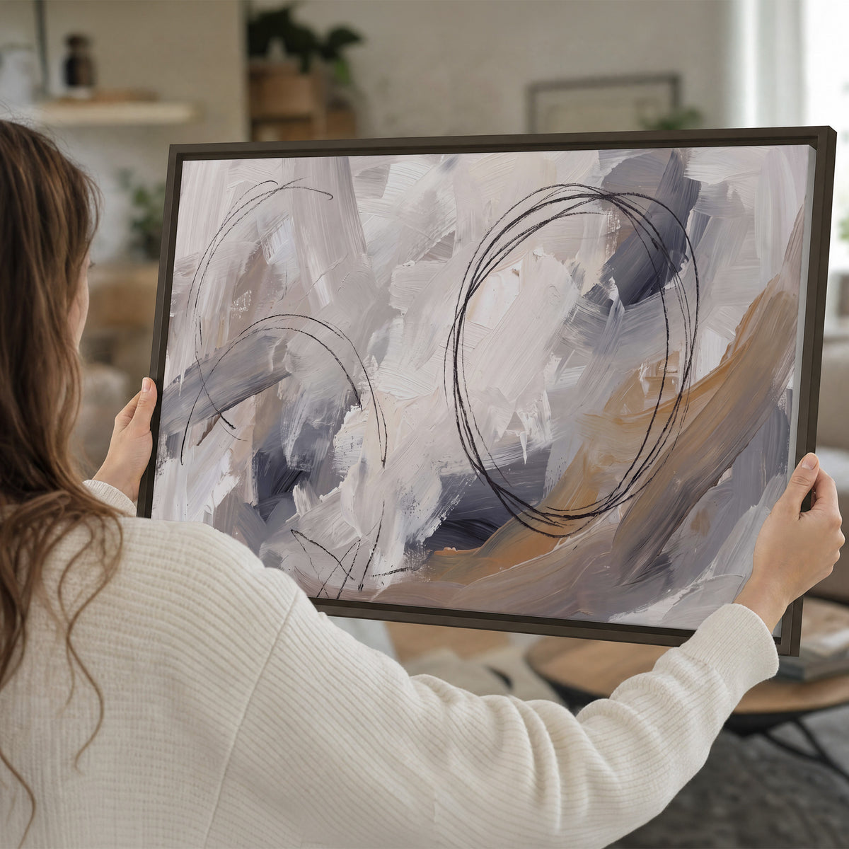 Expressive gray and cream abstract forms with fine gold-colored circular lines single framed canvas wall art held in hands