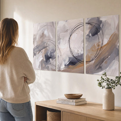 Expressive gray and cream abstract forms with fine gold-colored circular lines set of 3 poster prints three panel arrangement on a wall