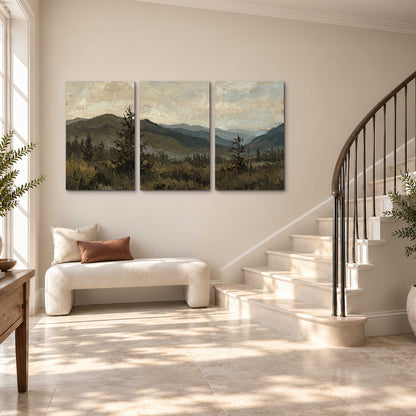 Layered mountain ridges and dark evergreen trees beneath a muted cloudy sky 3 piece canvas wall art styled in an interior