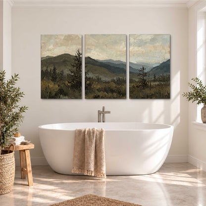 Layered mountain ridges and dark evergreen trees beneath a muted cloudy sky 3 piece canvas wall art styled in an interior