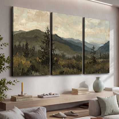 Layered mountain ridges and dark evergreen trees beneath a muted cloudy sky 3 piece canvas wall art displayed in a console
