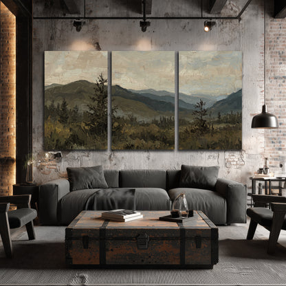 Layered mountain ridges and dark evergreen trees beneath a muted cloudy sky 3 piece canvas wall art displayed in a industrial room