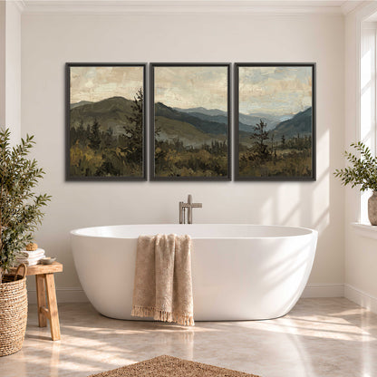 Layered mountain ridges and dark evergreen trees beneath a muted cloudy sky 3 piece framed canvas wall art styled in an interior