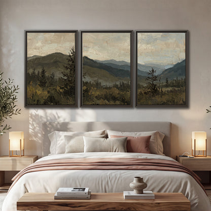 Layered mountain ridges and dark evergreen trees beneath a muted cloudy sky 3 piece framed canvas wall art displayed in a bedroom