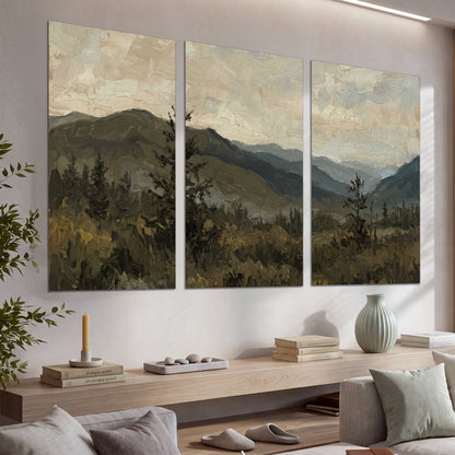 Layered mountain ridges and dark evergreen trees beneath a muted cloudy sky set of 3 poster prints displayed in a console