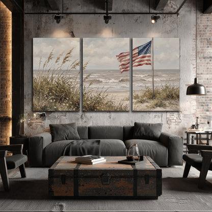An American flag above coastal grasses beside a quiet sandy beach 3 piece canvas wall art displayed in a industrial room